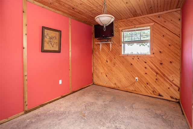 empty room with wood ceiling, concrete floors, and wood walls