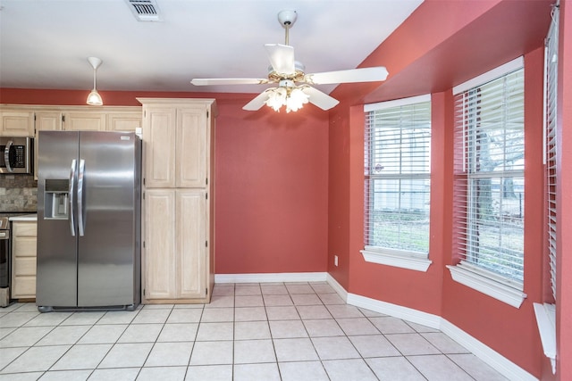 kitchen with ceiling fan, appliances with stainless steel finishes, decorative backsplash, and light tile patterned floors