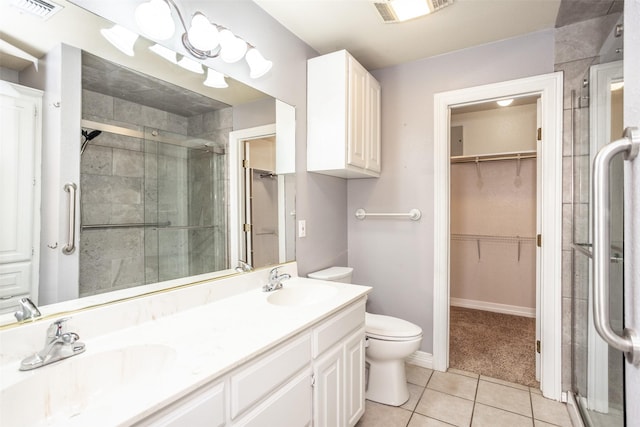 bathroom featuring vanity, a shower with shower door, tile patterned floors, and toilet