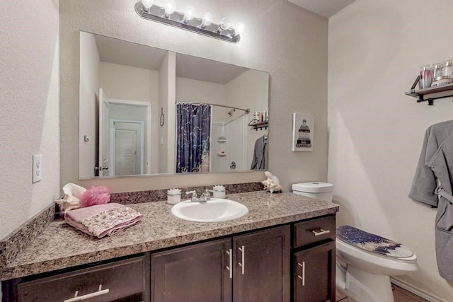 bathroom featuring a shower with shower curtain, vanity, and toilet