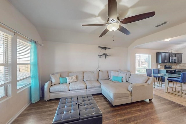 living room with dark hardwood / wood-style floors, ceiling fan, and lofted ceiling