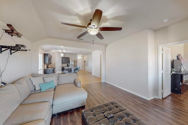 living room featuring ceiling fan, lofted ceiling, and dark wood-type flooring