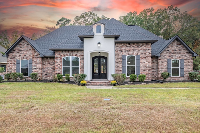 french country home with a lawn and french doors