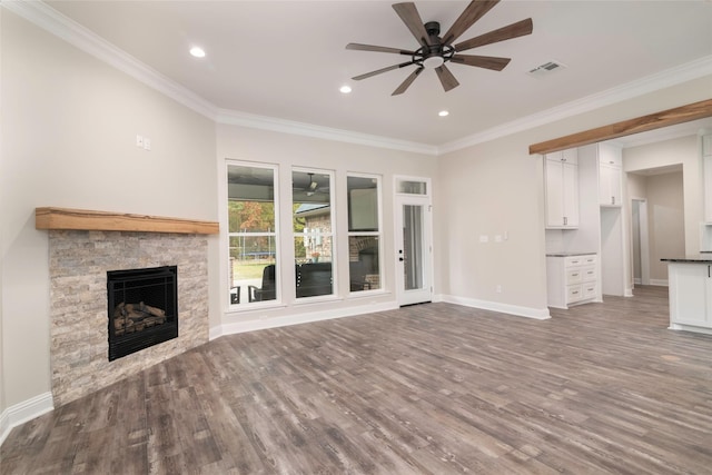 unfurnished living room featuring a stone fireplace, crown molding, ceiling fan, and wood-type flooring