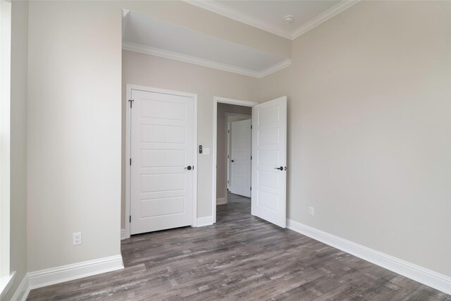 spare room featuring crown molding and dark hardwood / wood-style flooring