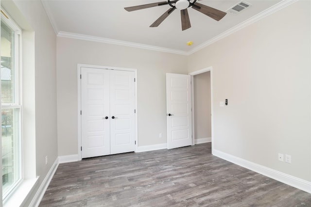 unfurnished bedroom with a closet, ceiling fan, crown molding, and hardwood / wood-style flooring