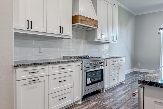 kitchen with premium range hood, dark wood-type flooring, crown molding, double oven range, and white cabinetry