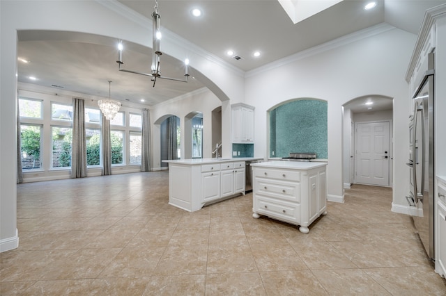 kitchen with white cabinetry, an inviting chandelier, decorative light fixtures, a center island, and dishwasher