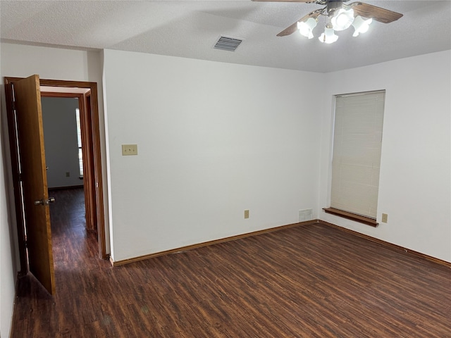 unfurnished room featuring a textured ceiling, dark wood-type flooring, and ceiling fan