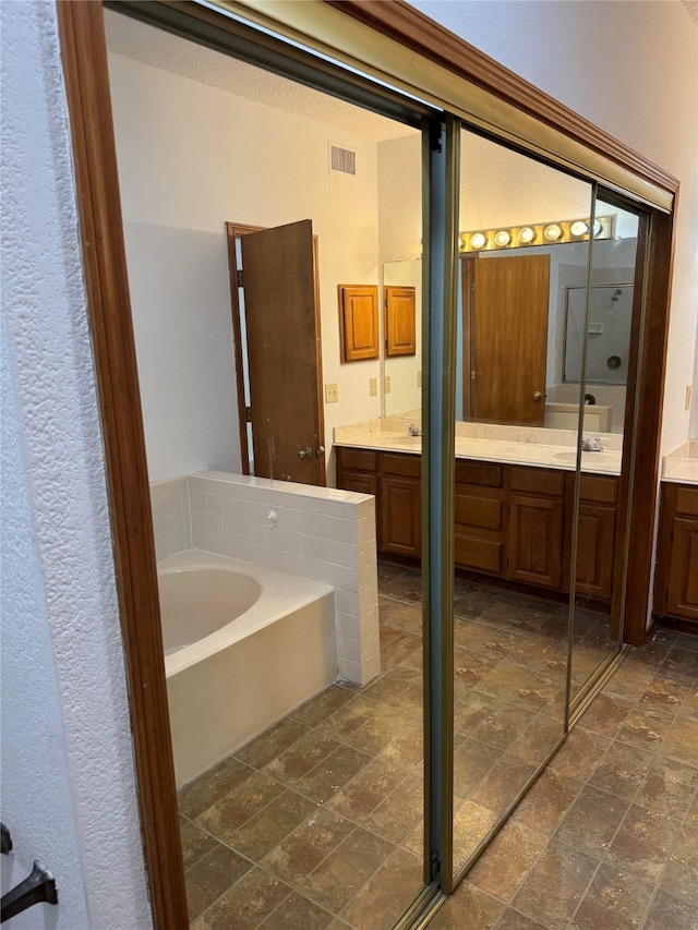 bathroom featuring vanity and shower with separate bathtub