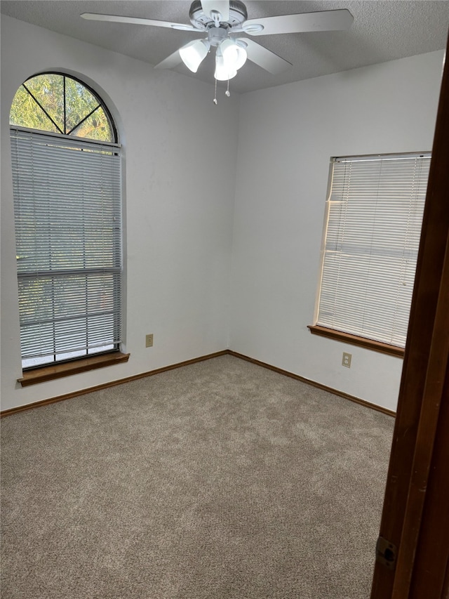 spare room featuring ceiling fan, a textured ceiling, and carpet floors