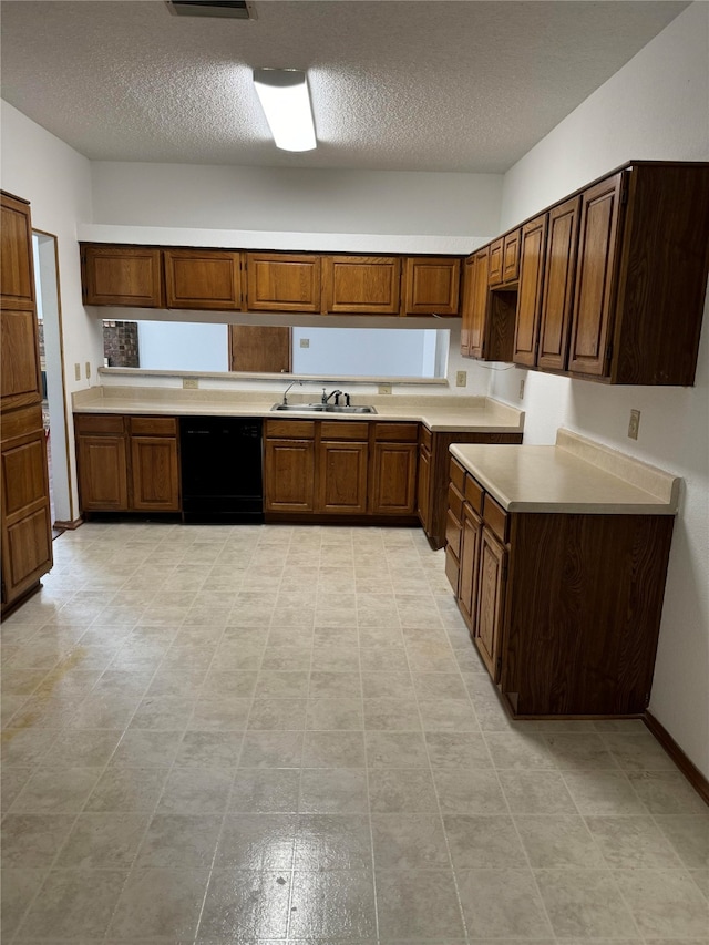 kitchen featuring a textured ceiling, black dishwasher, sink, and light tile patterned floors