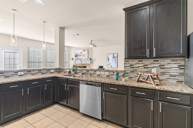 kitchen featuring tasteful backsplash, sink, pendant lighting, stainless steel dishwasher, and light stone counters