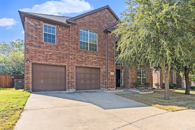 view of front of property with a front yard, central AC unit, and a garage