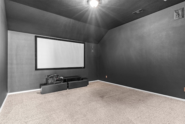 home theater featuring vaulted ceiling and carpet flooring