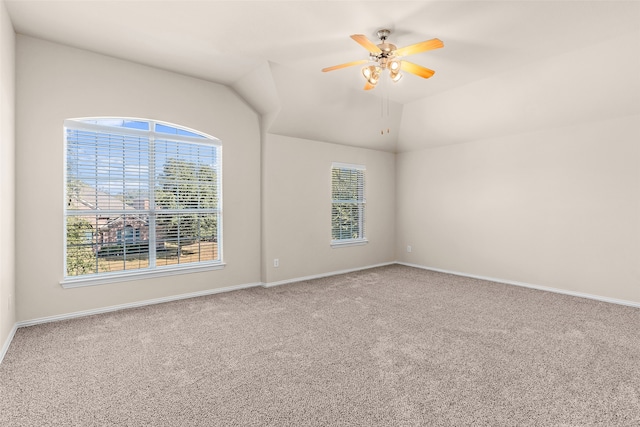 unfurnished room with ceiling fan, a healthy amount of sunlight, vaulted ceiling, and carpet floors