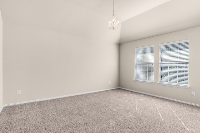 empty room featuring an inviting chandelier, carpet, and vaulted ceiling