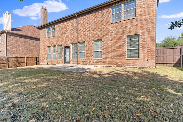 back of property with a patio area and a lawn