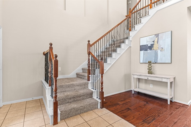 stairway featuring a high ceiling and hardwood / wood-style flooring