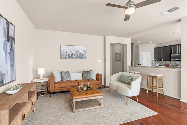 living room featuring ceiling fan and hardwood / wood-style floors