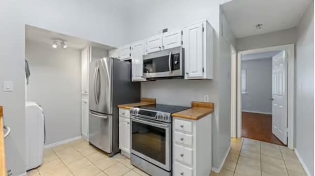 kitchen featuring white cabinets, light tile patterned flooring, and appliances with stainless steel finishes