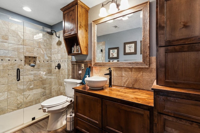 full bathroom with vanity, toilet, wood finished floors, tasteful backsplash, and a stall shower