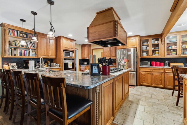 kitchen with stainless steel appliances, stone counters, a kitchen breakfast bar, and tasteful backsplash