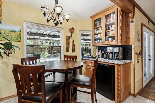 interior space featuring wine cooler, baseboards, an inviting chandelier, and a wealth of natural light