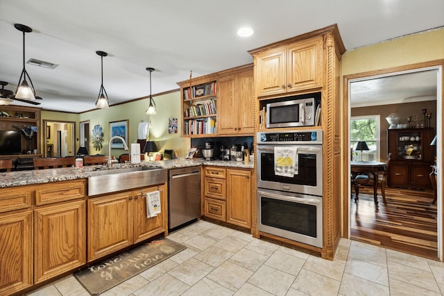 kitchen with a sink, appliances with stainless steel finishes, crown molding, and visible vents