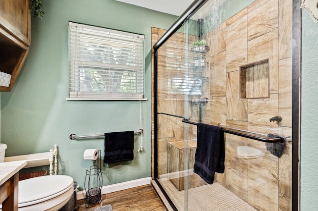 full bath with vanity, a stall shower, toilet, and wood finished floors