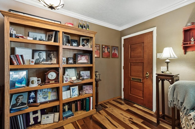 entryway featuring baseboards, ornamental molding, and wood finished floors