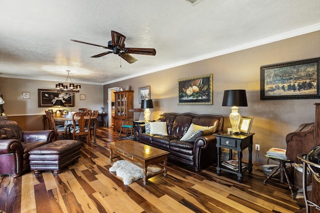 living room featuring ornamental molding, ceiling fan with notable chandelier, hardwood / wood-style flooring, and a textured ceiling