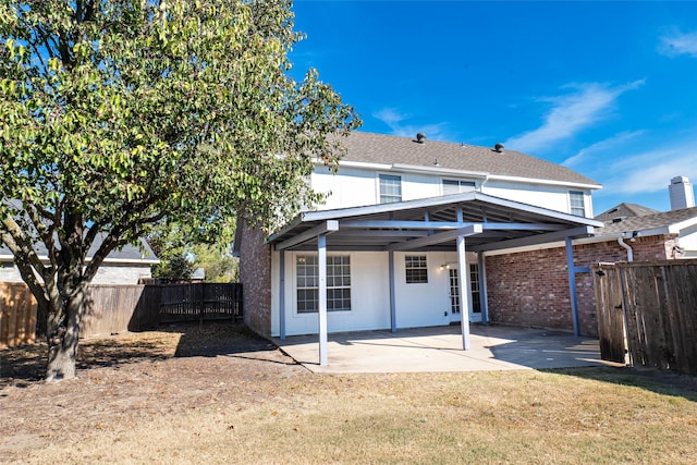 rear view of property featuring a patio area and a lawn