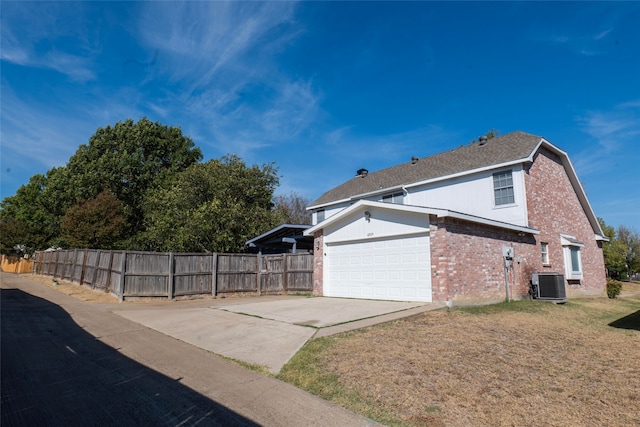 view of side of home featuring central AC, a yard, and a garage