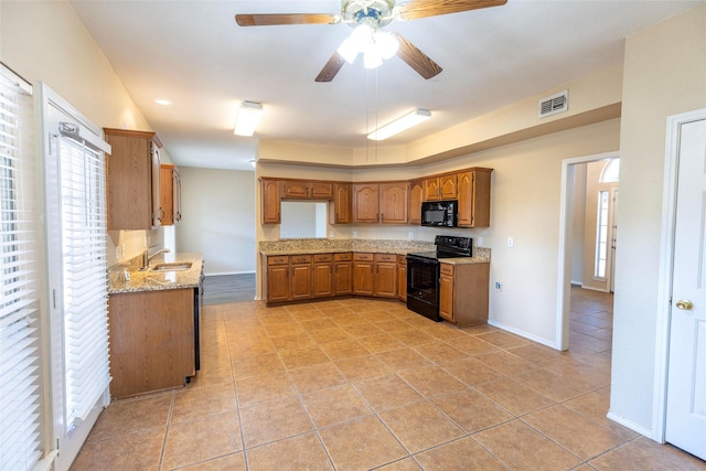 4309 Sarasota Ln, Mckinney, TX 75070 - kitchen featuring brown cabinetry, visible vents, light stone countertops, light tile patterned floors, and black appliances