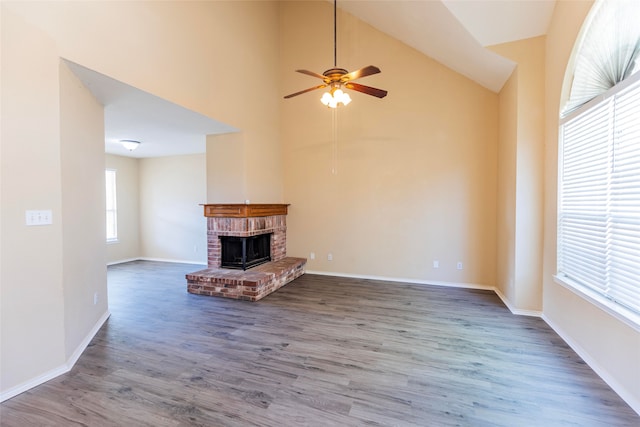 unfurnished living room featuring dark hardwood / wood-style floors, high vaulted ceiling, a fireplace, and ceiling fan