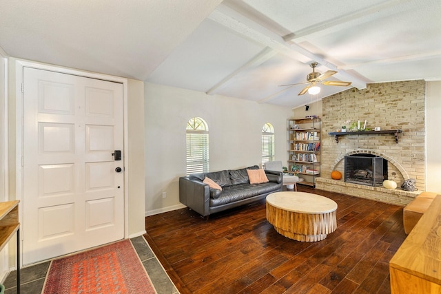 living room with ceiling fan, a fireplace, lofted ceiling with beams, and dark hardwood / wood-style floors