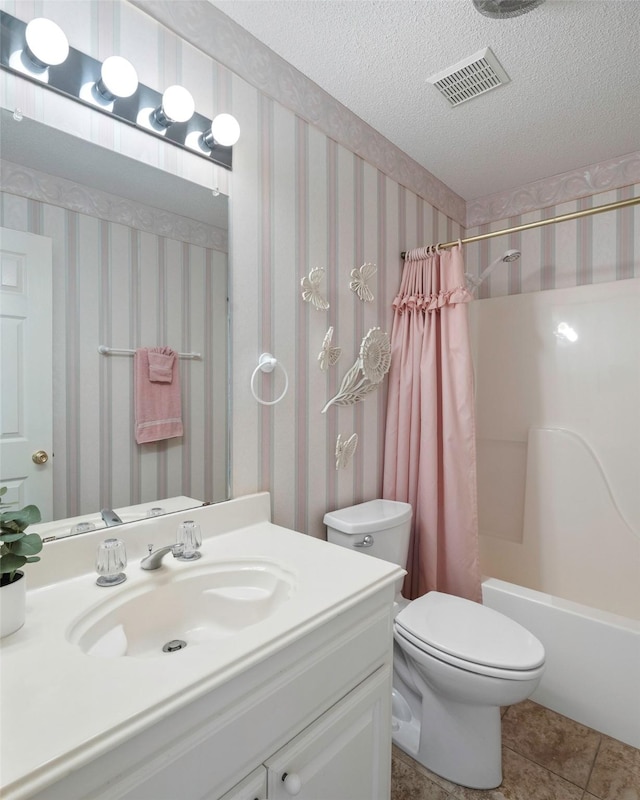 full bathroom featuring tile patterned flooring, vanity, a textured ceiling, toilet, and shower / bath combo with shower curtain