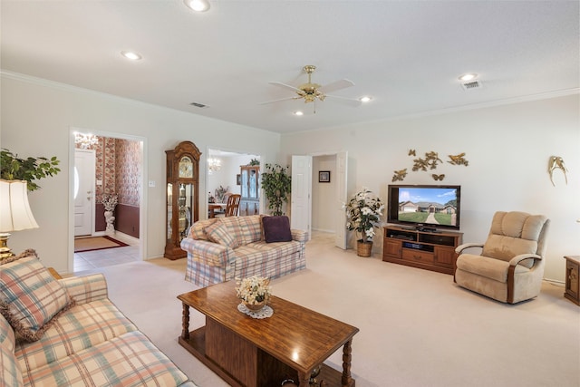 carpeted living room featuring ornamental molding and ceiling fan