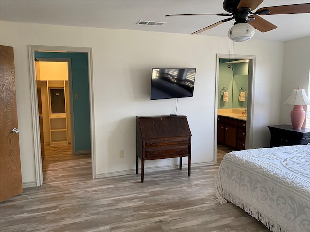 bedroom featuring ensuite bath, sink, and light hardwood / wood-style flooring