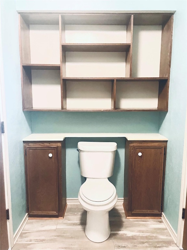 bathroom with hardwood / wood-style floors and toilet