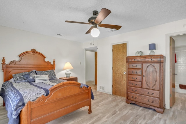 bedroom with ceiling fan, a textured ceiling, and light hardwood / wood-style flooring