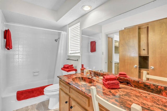 full bathroom featuring hardwood / wood-style floors, vanity, a textured ceiling, toilet, and shower / bath combo with shower curtain