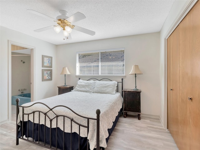 bedroom featuring ceiling fan, a textured ceiling, a closet, and light wood-type flooring