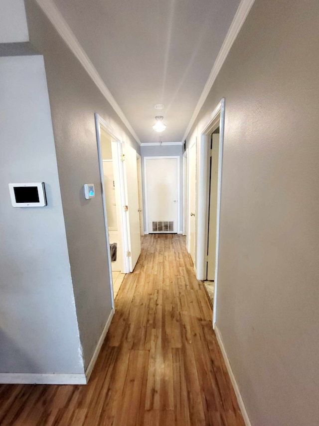 corridor featuring crown molding and light wood-type flooring