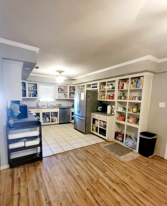 kitchen featuring light hardwood / wood-style flooring, ornamental molding, white cabinets, appliances with stainless steel finishes, and ceiling fan