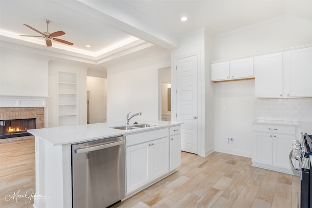 kitchen featuring white cabinetry, stainless steel appliances, light wood-type flooring, and a center island with sink