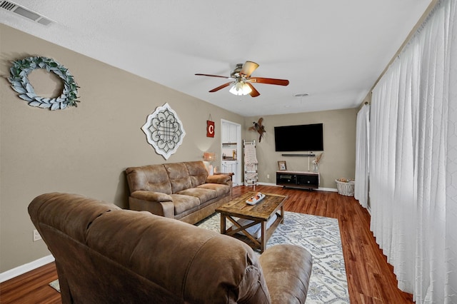 living room featuring dark hardwood / wood-style floors and ceiling fan