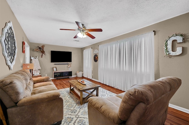 living room with hardwood / wood-style floors, a textured ceiling, and ceiling fan