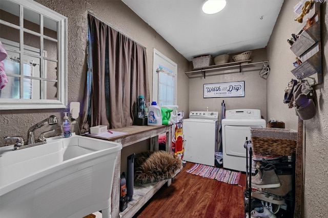 laundry room featuring plenty of natural light, sink, dark wood-type flooring, and washing machine and dryer